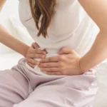 Perempuan kesakitan sambil memegang perut saat menstruasi