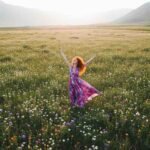 seorang perempuan tampak gembira di padang bunga