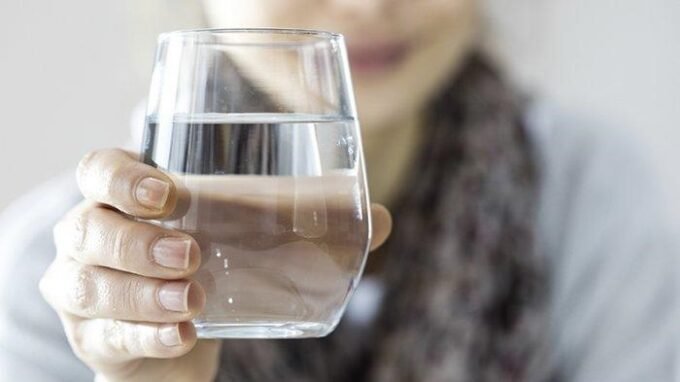 Seseorang minum air putih saat bangun tidur