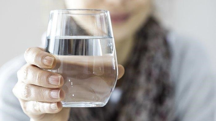 Seseorang minum air putih saat bangun tidur